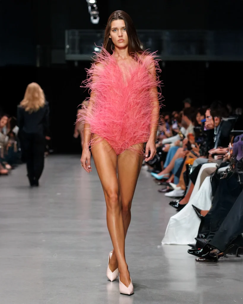 Model on the runway at Paris Fashion Week wearing a bright pink bodysuit by Stella McCartney, made with Fevvers’ vegan, plant-based feather alternative.